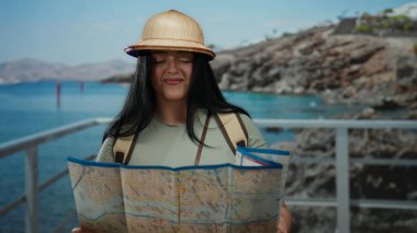 Kadın turist haritası açık deniz manzaralı açık hava haritası şapka takıyor ve macera dolu seyahat titreşimleri oluşturuyor..