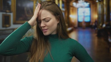 Müze binası koridorunda süslü dekorlarla el ele dinlenen beyaz bir kadın. Stres..