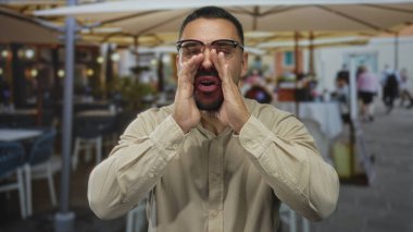 Restoran binasının önünde el ele tutuşup bağıran adam; coşkulu bir iletişim..