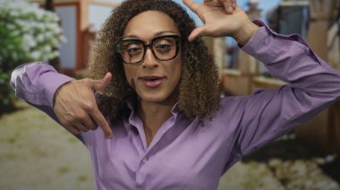 Yeşil parkta parmakları bulanık yaprakları ve tahta çitleri olan kadın çerçeveleri; sevinç kutlamaları.