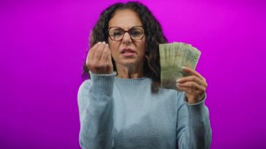 Arjantinli banknotları elinde tutan orta yaşlı bir kadın, mali konularda hayal kırıklığına uğramış görünüyor..