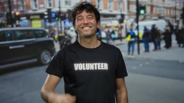 Meşgul bir sokakta gülümseyen ve onay veren İspanyol bir adam, gönüllü bir gömlek giyiyor, şehir dışı aktiviteleri ve yayalarla çevrili..