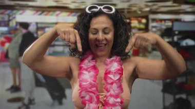 Çıplak kollu İspanyol kadın işaret parmağı mağazada aşağı doğru; promosyon indirimi davetiyesi.