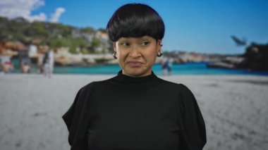 Genç Asyalı bir kadın, güneşli bir sahil gününde neşeli bir arka planda tiksinti ifadesi sergiliyor..