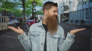 Kot ceketli adam nazikçe avuçlarını açar ve güneşli tuğlalı kaldırımlı şehir caddesinde gülümser; belirsizlik.