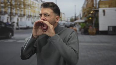 Şehir caddesinde bağırmak için elleri olan, trafiği bulanık, kaldırımı açık bir adam..