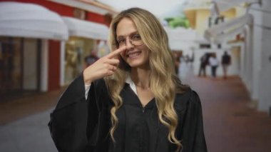 Kadın, bir sokak sahnesinde burnuna parmağıyla dokunuyor. Açık havada gülümseyen üniformalı genç sarışın bir yargıcı gösteriyor..