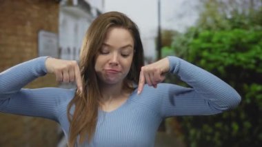 Arkadaki bulanık yeşillik ile caddede mavi süveter giyen kadını işaret etmek; davetiye dikkat.