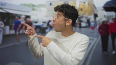 Kalabalık bir şehir sokağında ağzı açık parmaklarını gösteren adam; sürpriz heyecan şaşkınlık neşe.