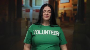 Uzun saçlı, gönüllü gömlekli bir kadın geceleri şehir sokaklarında dikiliyor, toplum ruhunu sergiliyor, açık hava ortamında gönüllülüğe odaklanıyor..