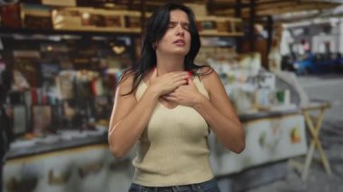 Sokakta elleri ve elleri ile göğüs ve boğaz bastıran İspanyol kadın, gözleri kapalı ve dudakları ayrık; sıkıntı sıkıntı acı mücadele.