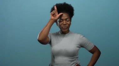 Kaybeden kadın kendine güveni olan, kendine güvenen, ifadesini somutlaştıran ve sıradan bir şekilde hareket eden mavi arka plan üzerinde imza attırıyor..