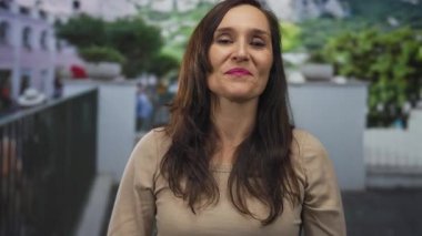 Genç İspanyol kadın açık hava meydanında gülümserken işaret parmağıyla göğsünü işaret ediyor..