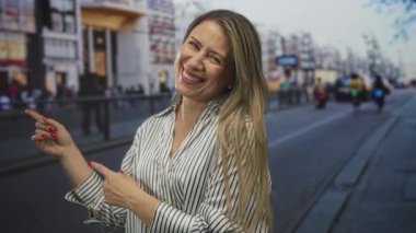 Parmakla işaret eden uzun sarı saçlı kadın şehir caddesinde bulanık vitrinleri ve tramvay rayları manzaralı, neşe dolu..