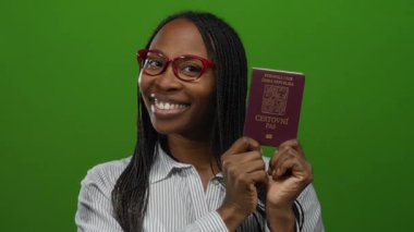Yeşil arka planda Czech pasaportu taşıyan gülümseyen kadın, örgülü ve gözlüklü seyahat belgesi sergiliyor..