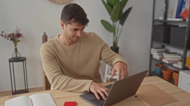 Evde tıklayan erkek dizüstü bilgisayar İspanyol genç öğrenci masadaki yaratıcılığa ilham veriyor..