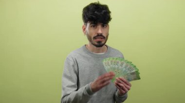 Sarı arka planda Rus rublesi tutan adam kendinden emin görünüyor ve fısıldıyor..