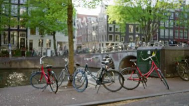 Amsterdam 'da kanalda sıralanmış bisikletler, dağılmış binalar ve ağaçların klasik bir Avrupa ambiyansı oluşturduğu büyüleyici bir sahne yaratıyor..