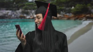 Mezuniyet elbisesi giymiş, elinde Tayland pasaportu olan genç bir kadın. Neşeli bir ifadeyle, özgürlüğü ve yeni başlangıçları simgeliyor..