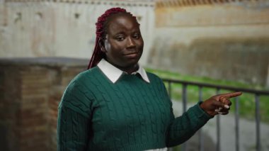 Roma harabelerinde gülümseyen yeşil kazaklı kadın Roma şehrinin arka planında antik tarih ve kültür sergiliyor..