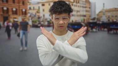 Bulanık yayalar ve tarihi binalarla kalabalık şehir caddesinde el ele tutuşan bir adam reddedilmeyi reddediyor..