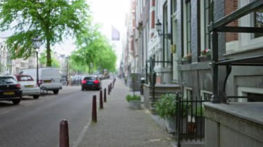 Aydınlık bir günde Avrupa 'nın bulanık sokak sahnesinde odaklı olmayan arabalar ve binalar arka planda.