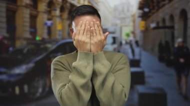 Şehir caddesinde neşeli ifadeler takınan genç İspanyol bir adam. Bulanık sarı bir taksi geçmişi var. Açık hava manzarası çok canlı..