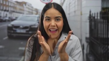 Şehir sokaklarında gülümseyen bir kadın, neşeli bir ifade ve uzun saçla gelişigüzel giyinmiş, şehir ortamında mutluluğu ve güveni gösteriyor..