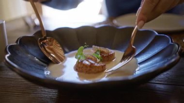 Akdeniz restoranında deniz ürünleri ile nefis bir akşam yemeği yiyen bir kadın, gurme mutfak sunumunu detaylara dikkat ederek kapalı mekanda sunuyor..