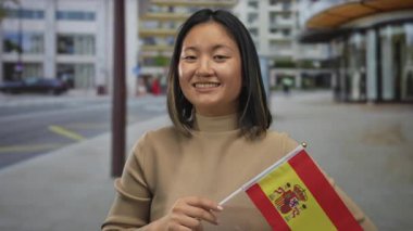 Bir kadın, İspanya bayrağını açık havada tutarken gülümsüyor İspanya 'da çok kültürlülük ve gurur olduğunu söylüyor..