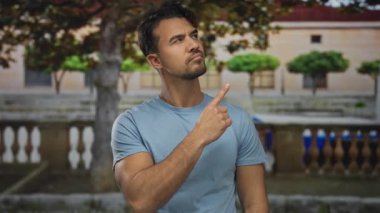 Serin bir bahçe ortamında farklı ifadelerle gösterilen genç İspanyol adam, yemyeşil bir çevre ve tarihi mimari arasında merak ve tefekkür harmanlıyor..