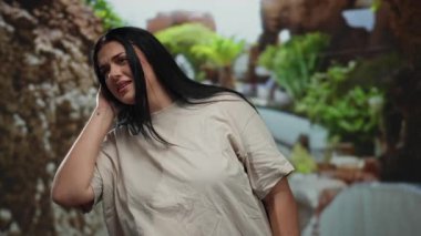 Kıvrımlı genç kadın parkta el pençe divan dinlerken yemyeşil ortamda doğal cazibe ve özenli ifadeyle dolu çekici bir açık hava sahnesi yaratıyor..