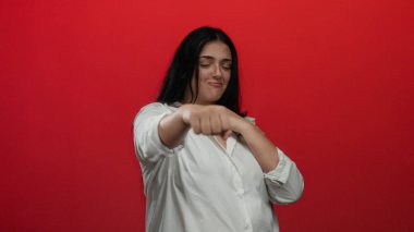 Cesur, kırmızı bir zemine karşı kendine güveni olan genç ve cüsseli bir kadın boks yapıyor. Güçlendirme ve kararlılığa odaklanıyor..