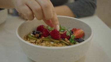 Modern lüks restoranda sağlıklı salatanın tadını çıkaran bir kadın. Taze meyve ve tahıl gevreğiyle birlikte kapalı bir masada beslenme ve yaşam tarzını öne çıkarıyor..