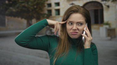 Taş bina cephesinden önce parke taşı caddesindeki tapınakta akıllı telefonu kulağına tutan kadın hayal kırıklığı..