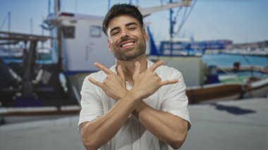 Kaya boynuzlarını deniz kıyısında güneşli bir caddede teknenin önünde çıplak elle hareket ettirir..