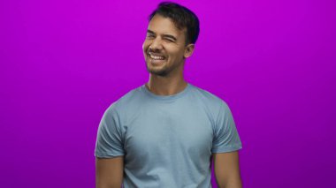 İzole edilmiş pembe bir arka planda güvenle gülümseyen genç adam çeşitli temalar için canlı, neşeli ve modern bir ifade sergiliyor..