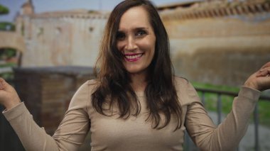 Genç İspanyol kadın harabelere zıt yönleri işaret ediyor; belirsizlik kararı yönü.