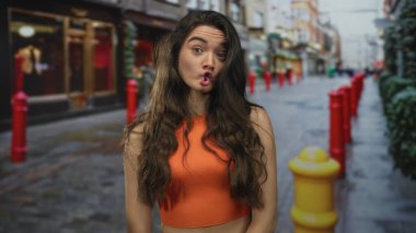 Kadın yüzü turuncu tepeli dar kaldırım taşı caddesinde gülümsüyor, vitrin kenarlarında kırmızı kalınlar, neşe..