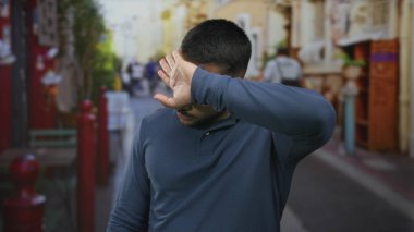 İnsan, güneşli, hareketli şehir caddesinde alnından ter silerken renkli dükkanlar çizer; ısı yorgunluğu giderici.