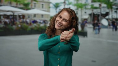 Şehir sokaklarında gülümseyen ve alkışlayan bir kadın sıradan bir ortam yaratıyor. Mutluluğu ve şehir yaşamını gösteren canlı bir atmosfer yaratıyor..