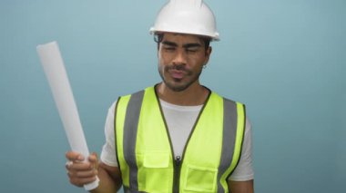 Yelek giyen İspanyol mühendis mavi stüdyoda el yapımı ve eğimli planlar taşıyordu. Güven gururu profesyonelliği..