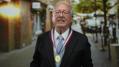 Takım elbiseli kıdemli bir adam hayat dolu bir sokakta cesur bir jest yapıyor, dramatik bir açık hava sahnesi sergiliyor..