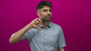 Genç İspanyol adam, stüdyoda el kaldırarak açıkça baş parmağını aşağı gösteren bir hareket sergiliyor..