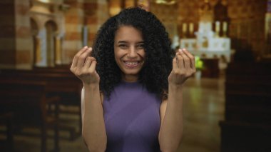 Latin kökenli genç kadın, tarihi kilise binasında banknotları sayarak el kol hareketi yapıyor..