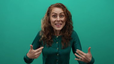 Canlı yeşil bir arka plan karşısında heyecanlı jestler yapan kadın kıvırcık saçlarını ve hareketli bir portrede canlandırılmış yüz ifadelerini vurguluyor..