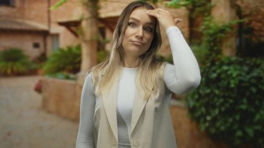 Gündüz vakti bir tefekkür ifadesiyle tuhaf bir şehir sokağında dikilirken düşünceli görünen sıradan giysili bir kadın..