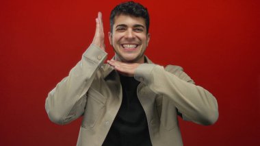 Adam arka planda kırmızı duvarda neşeli bir gülümsemeyle genç İspanyol 'un portresini çerçeveletiyor..