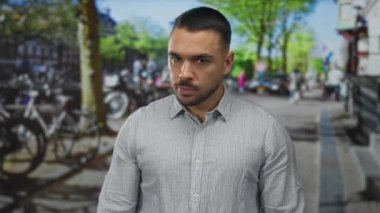 Genç İspanyol bir adam kalabalık bir şehir sokağında zorla avucunu yumrukluyor. Öfke gerilimi..