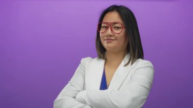 Kırmızı gözlüklü ve beyaz ceketli genç Çinli kadın canlı mor duvarlara gülümsüyor, kendine güveni ve tarzı var..